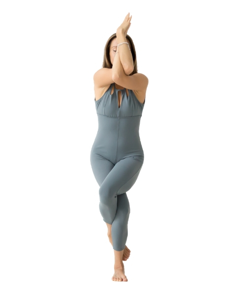 A woman performing garudasana, a body twisting yoga pose to boost metabolism.